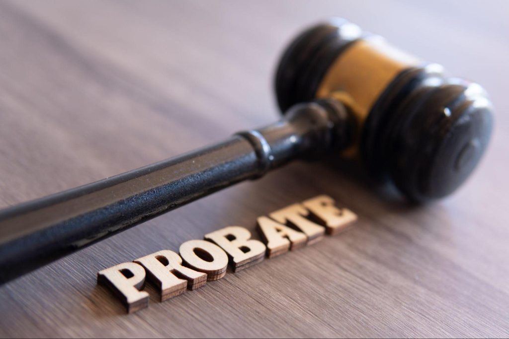 A gavel on a wooden table with the word "probate" in wooden letters.