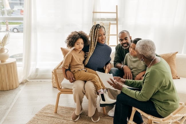 multigenerational black family discussing life insurance documents in the living room area