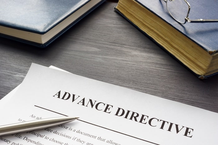 advance directive papers on a desk with other books and a pen